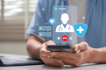 Healthcare professional in scrubs holding a smartphone displaying a doctor avatar with floating telemedicine icons (heart, chat, shield).
