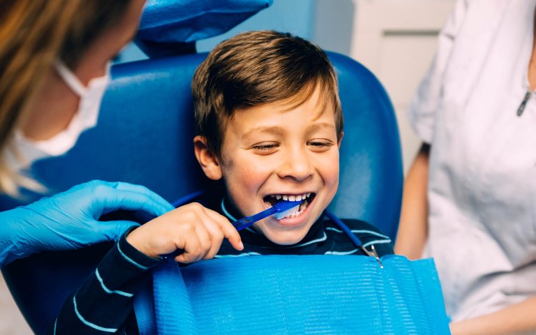 doctor-dentist-teaching-a-child-to-brush-teeth-2021-08-27-22-49-33-utc.jpg